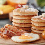 Artist signature pancake with sausage, bacon and berries (招牌煎饼) (panqueque especial) (crêpe signature) (signatur-pfannkuchen) (pancake speciale)