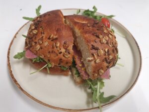 EN: Salted beef bagel with pickle, mustard and rocket CN: 咸牛肉贝果（酸黄瓜、芥末和芝麻菜） ES: Bagel de carne salada con pepinillo, mostaza y rúcula FR: Bagel au bœuf salé avec cornichon, moutarde et roquette DE: Salted Beef Bagel mit Gewürzgurke, Senf und Rucola IT: Bagel con manzo salato, cetriolo sottaceto, senape e rucola JA: 塩漬けビーフ、ピクルス、マスタード、ルッコラのベーグル NL: Bagel met salted beef, augurk, mosterd en rucola