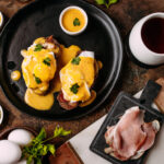 Eggs Benedict with poached eggs, bacon and hollandaise in Shoreditch near Old Street – popular brunch dish (班尼迪克蛋) (huevos benedict) (œufs bénédicte) (benedikt frühstück) (エッグベネディクト) (uova benedict).